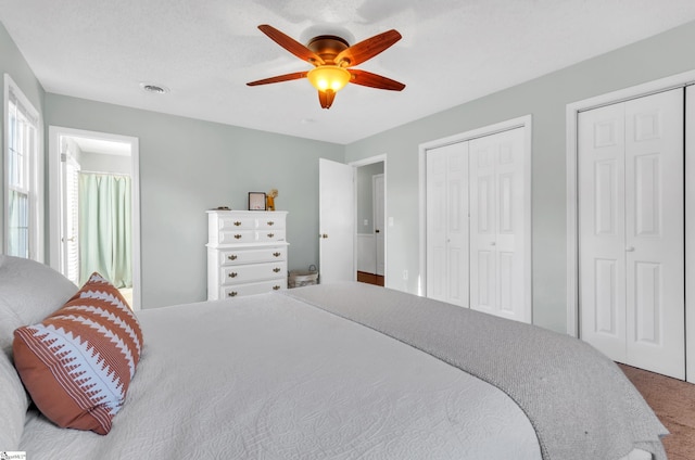 carpeted bedroom with multiple closets and ceiling fan