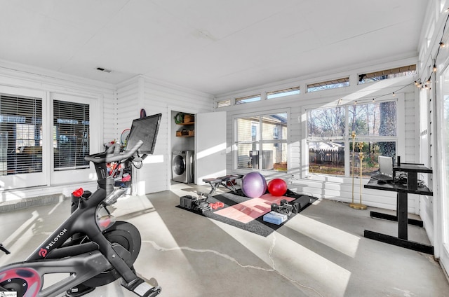 workout room featuring separate washer and dryer and ornamental molding