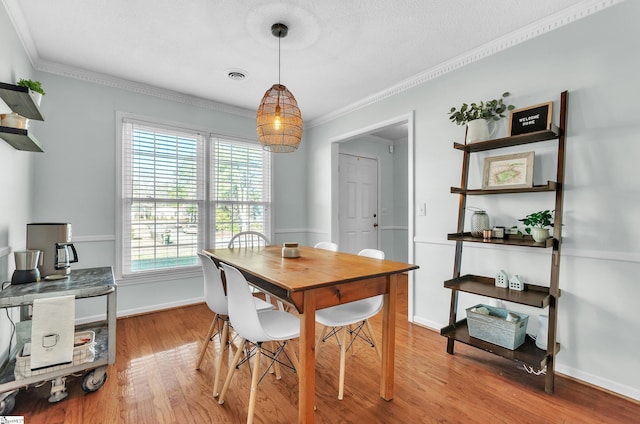 dining area featuring light hardwood / wood-style floors and ornamental molding