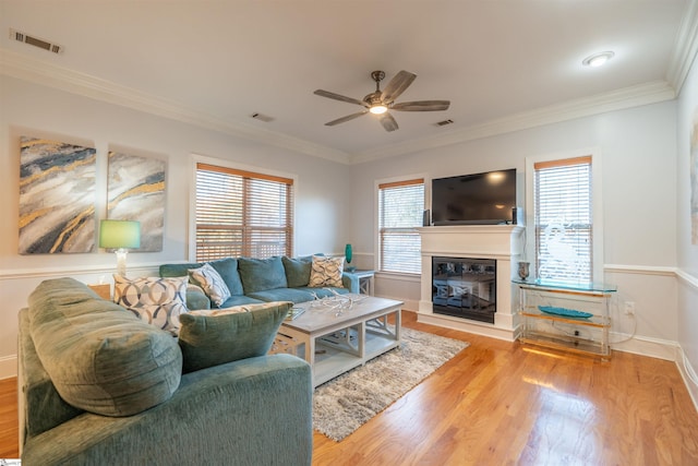 living room featuring crown molding, light hardwood / wood-style flooring, and ceiling fan