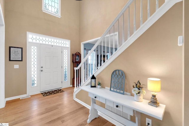 foyer entrance with hardwood / wood-style flooring and a high ceiling