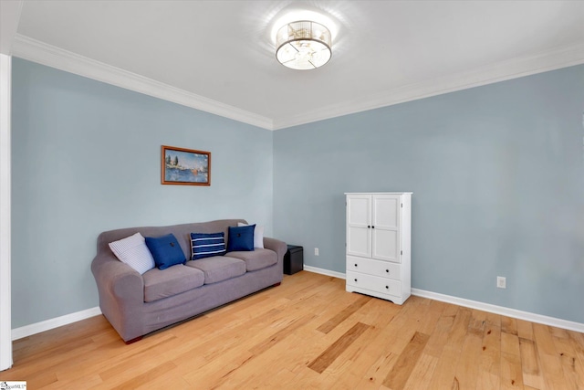 living room with ornamental molding and light hardwood / wood-style flooring