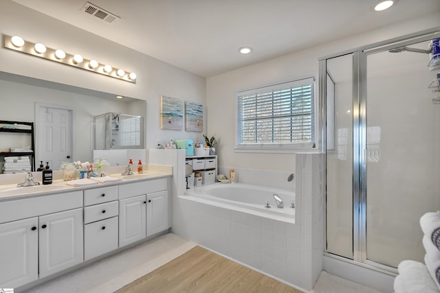 bathroom featuring hardwood / wood-style flooring, vanity, and shower with separate bathtub