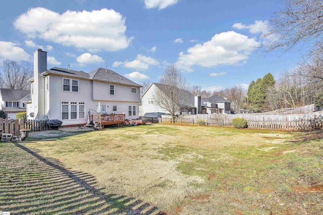 rear view of house with a deck and a lawn