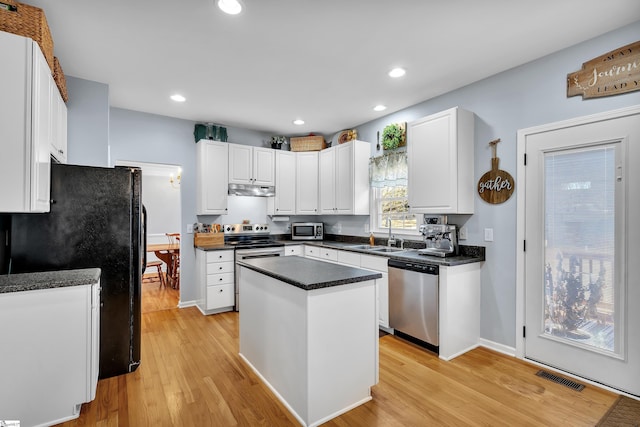 kitchen featuring white cabinetry, sink, a kitchen island, and appliances with stainless steel finishes