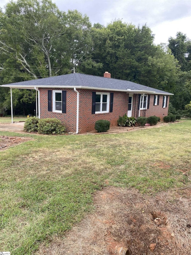 ranch-style house with a front yard and a carport