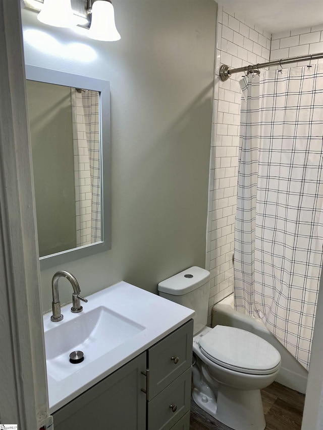 full bathroom with shower / bath combination with curtain, vanity, hardwood / wood-style flooring, and toilet