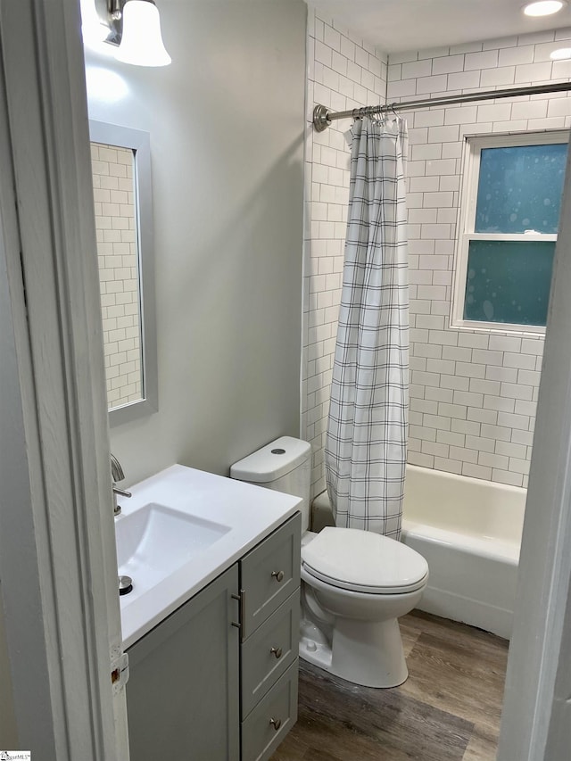 full bathroom featuring vanity, shower / bath combination with curtain, toilet, and wood-type flooring