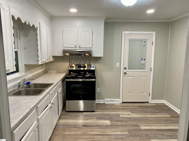 kitchen with light wood-type flooring, crown molding, sink, white cabinetry, and stainless steel electric range