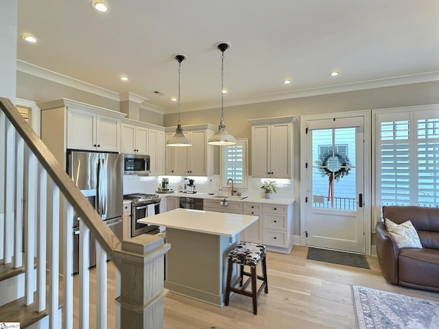 kitchen with pendant lighting, a center island, white cabinets, a kitchen breakfast bar, and stainless steel appliances