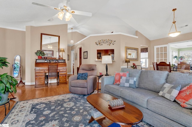 living room featuring hardwood / wood-style floors, vaulted ceiling, ceiling fan, and a healthy amount of sunlight