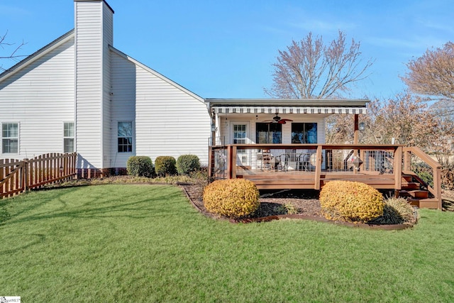 rear view of house featuring a yard, a deck, and ceiling fan