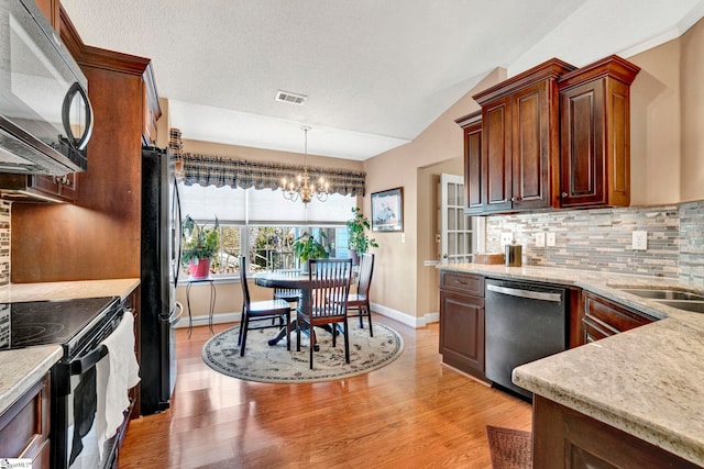 kitchen with decorative backsplash, black appliances, decorative light fixtures, an inviting chandelier, and lofted ceiling