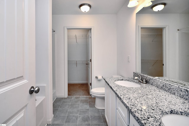 bathroom featuring a tub, vanity, and toilet