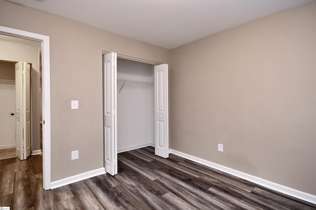 unfurnished bedroom featuring dark hardwood / wood-style floors and a closet