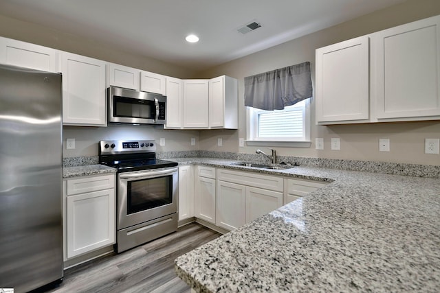 kitchen featuring white cabinets, appliances with stainless steel finishes, and sink