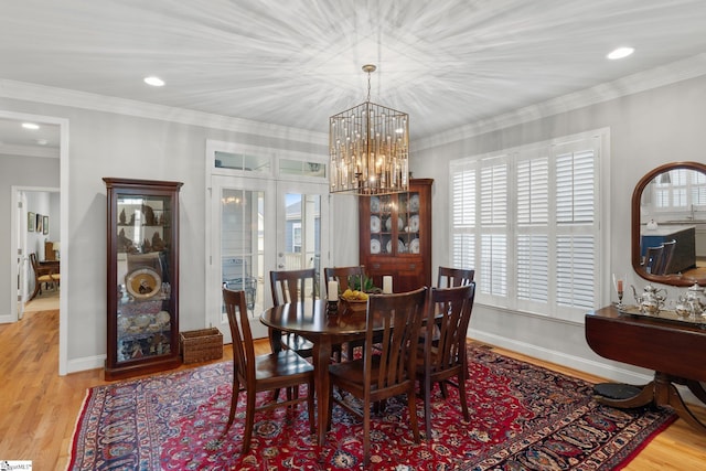 dining space featuring a chandelier, light wood-type flooring, and ornamental molding