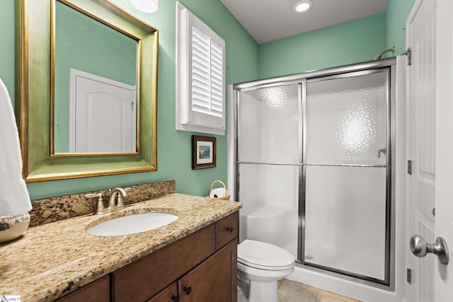 bathroom with tile patterned flooring, vanity, toilet, and walk in shower