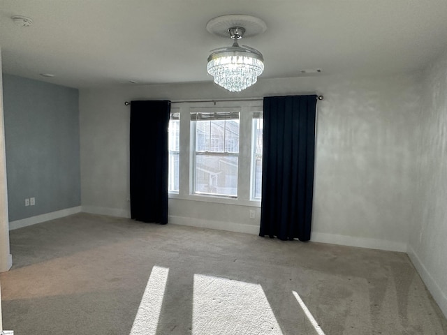 unfurnished room featuring light carpet and a notable chandelier