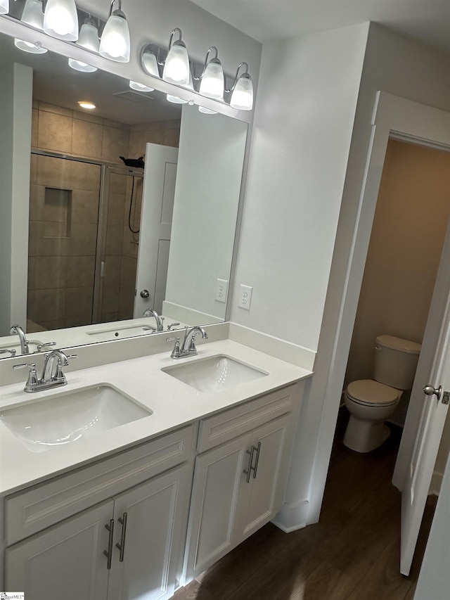 bathroom with vanity, toilet, a shower with door, and wood-type flooring