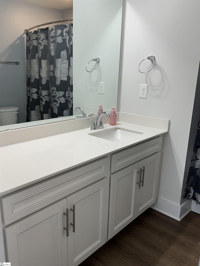 bathroom with vanity, hardwood / wood-style flooring, and toilet