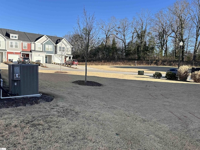 view of yard with a garage and central air condition unit