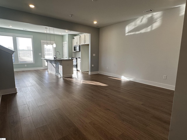 unfurnished living room featuring dark hardwood / wood-style flooring and sink