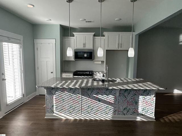 kitchen featuring dark hardwood / wood-style floors, sink, stainless steel appliances, and hanging light fixtures