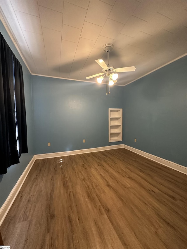 spare room featuring hardwood / wood-style floors, ceiling fan, built in features, and crown molding