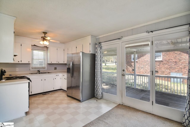 kitchen with ornamental molding, ceiling fan, sink, stainless steel fridge with ice dispenser, and white cabinetry