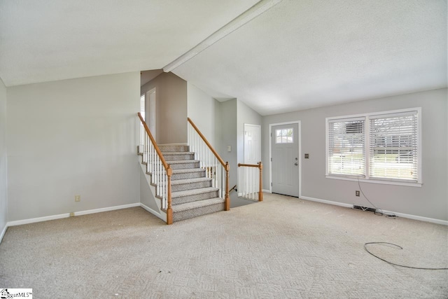 foyer featuring carpet and lofted ceiling with beams