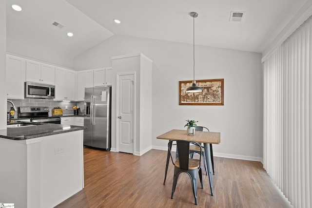 kitchen with sink, pendant lighting, decorative backsplash, white cabinets, and appliances with stainless steel finishes