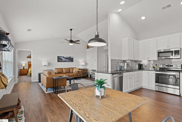 kitchen featuring white cabinetry, ceiling fan, stainless steel appliances, dark hardwood / wood-style flooring, and decorative backsplash