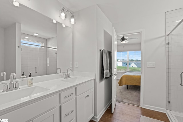 bathroom with ceiling fan, vanity, wood-type flooring, and walk in shower