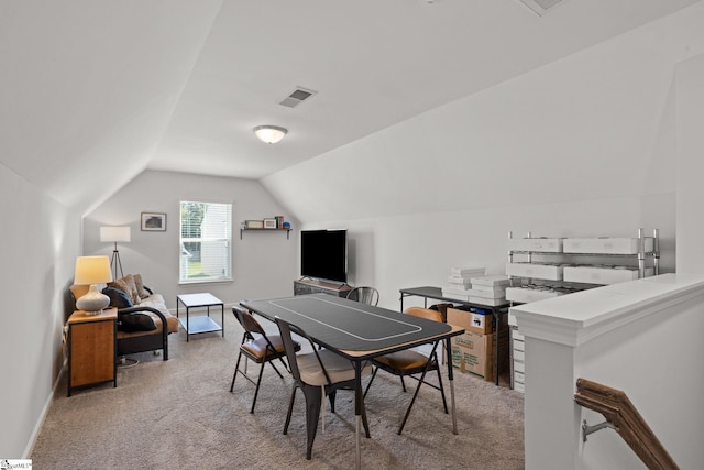 dining area with light colored carpet and vaulted ceiling