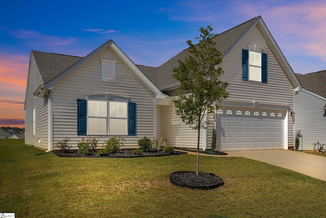 view of front of home with a garage and a yard