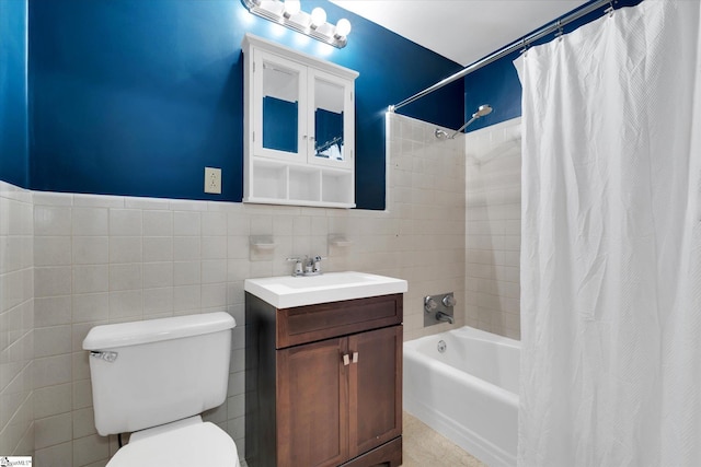 full bathroom with vanity, toilet, shower / bath combo with shower curtain, and tile walls