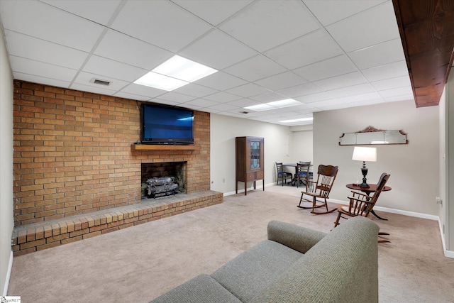 carpeted living room featuring a paneled ceiling and a fireplace