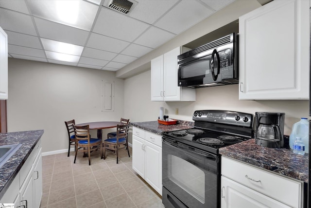 kitchen with a paneled ceiling, white cabinets, black appliances, and light tile patterned floors