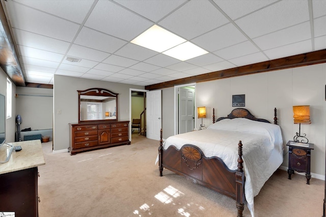 bedroom with a paneled ceiling and light colored carpet