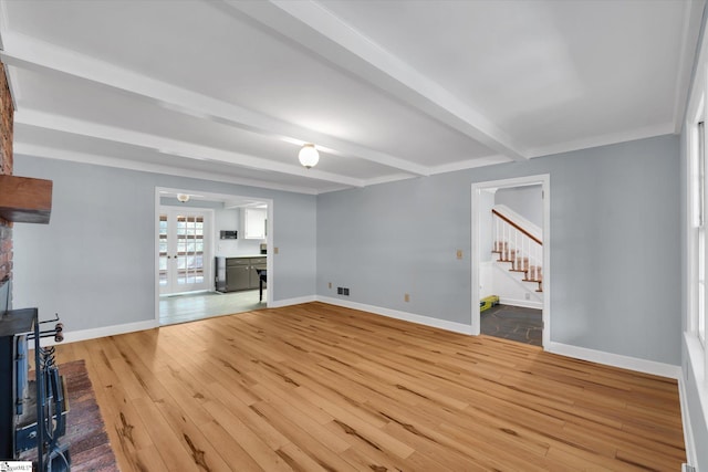 unfurnished living room featuring beamed ceiling and wood-type flooring