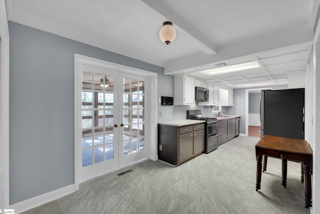 kitchen with beam ceiling, white cabinetry, sink, french doors, and appliances with stainless steel finishes