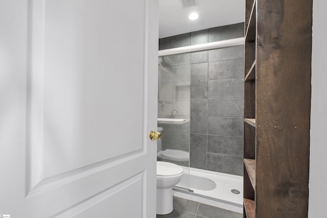 bathroom featuring an enclosed shower, tile patterned flooring, and toilet