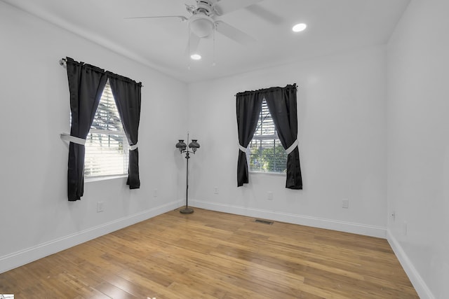 spare room featuring plenty of natural light, ceiling fan, and light hardwood / wood-style flooring