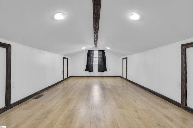 unfurnished living room featuring lofted ceiling with beams and light hardwood / wood-style floors