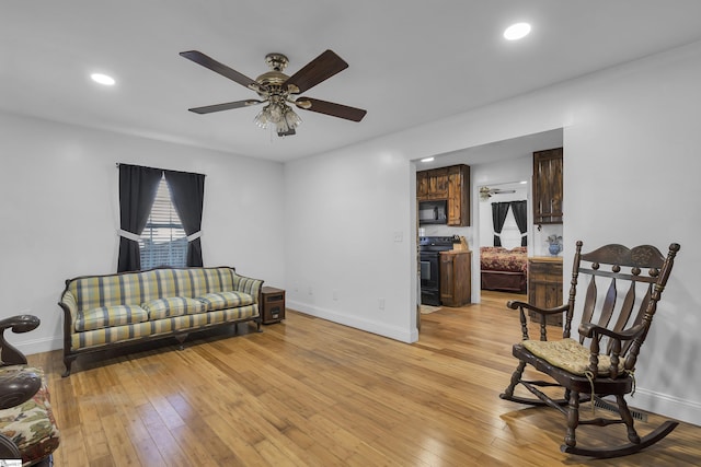 sitting room with light hardwood / wood-style flooring and ceiling fan