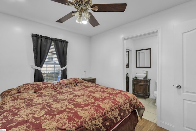 tiled bedroom featuring ceiling fan and connected bathroom