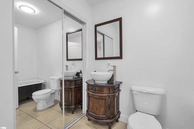 bathroom featuring tile patterned flooring, vanity, toilet, and a bathing tub