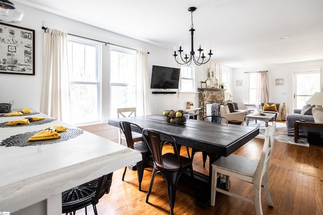 dining space featuring hardwood / wood-style flooring and an inviting chandelier