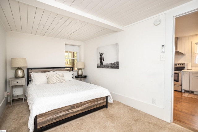 bedroom with ensuite bathroom, beam ceiling, light colored carpet, and wood ceiling